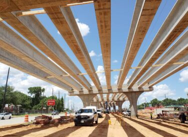 bridge beams across the sky with truck parked underneath SH 249 tollway