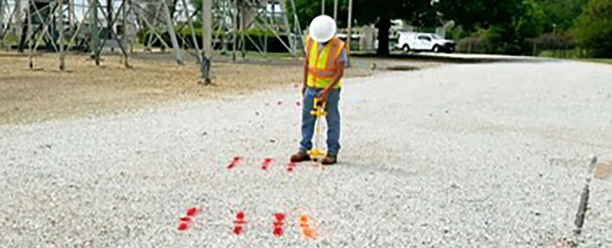 field crew member painting lines on road